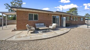 A brick building with a covered patio area, outdoor seating, and a grill. - Boho on Bermuda with Private Pool in Tucson (Tucson)