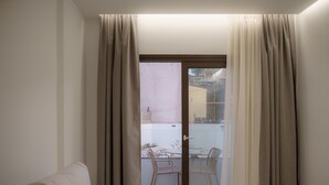 Habitación con puerta corrediza de vidrio que da a un espacio exterior con mesa y sillas.