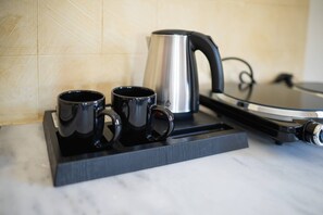 Minikylskåp, spishäll, vattenkokare och grytor/köksredskap