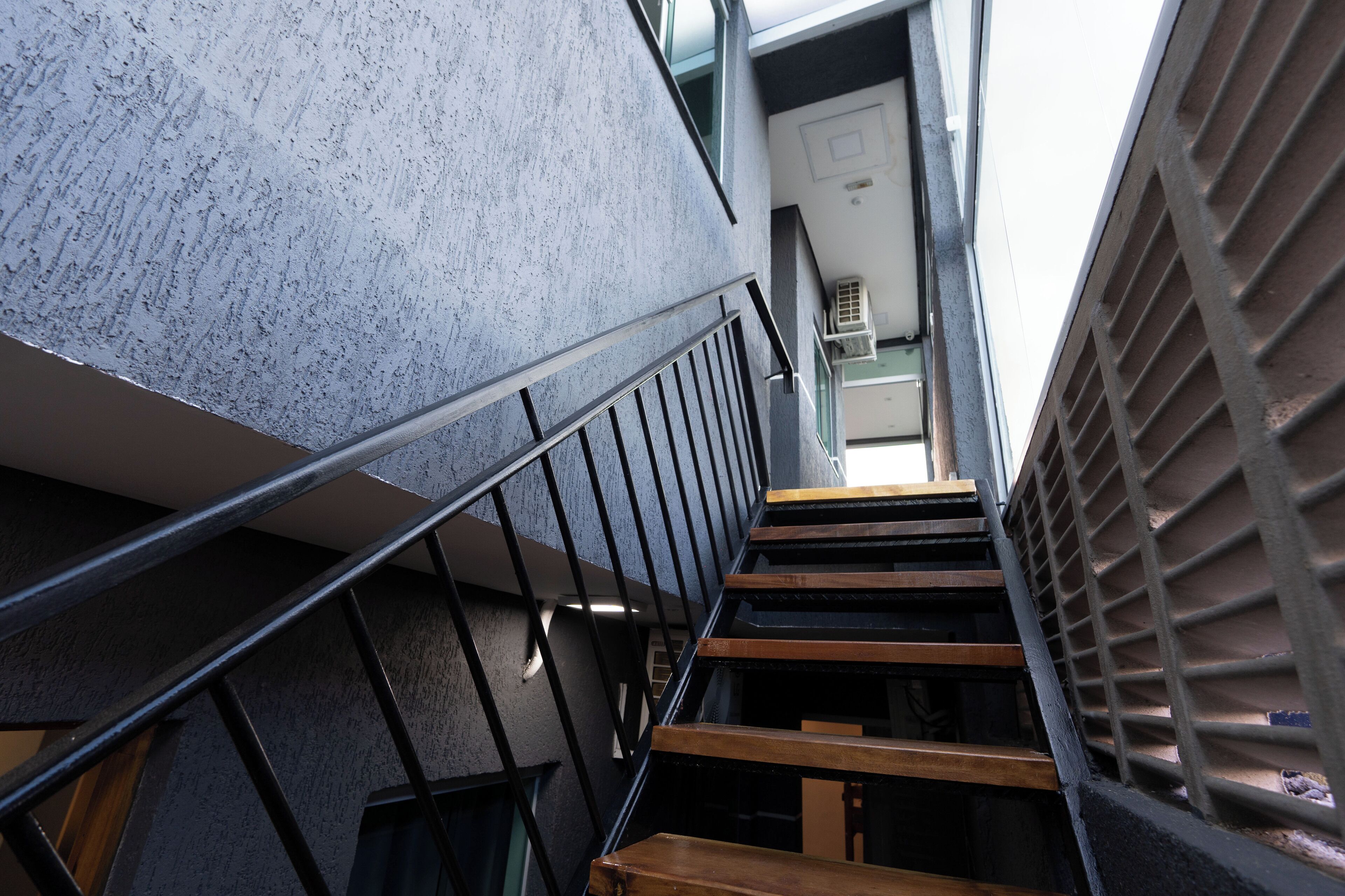 A staircase with metal railings and wooden steps, leading to an upper floor.