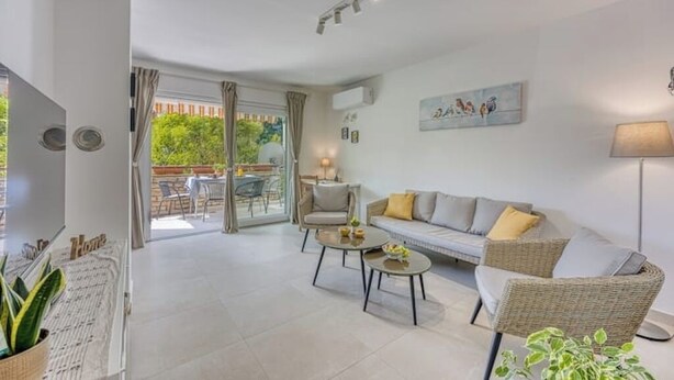 A modern living room with a sofa, two armchairs, a coffee table, and a dining area visible through glass doors. - Family Apartment - Cosy & Modern, 850 meters to the Sea (Porec)