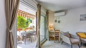 A room with a dining area, a small table with chairs, a sofa, and a window with curtains. - Family Apartment - Cosy & Modern, 850 meters to the Sea (Porec)