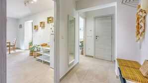 A modern interior with a dining area, a hallway, and a seating area with a sofa. - Family Apartment - Cosy & Modern, 850 meters to the Sea (Porec)