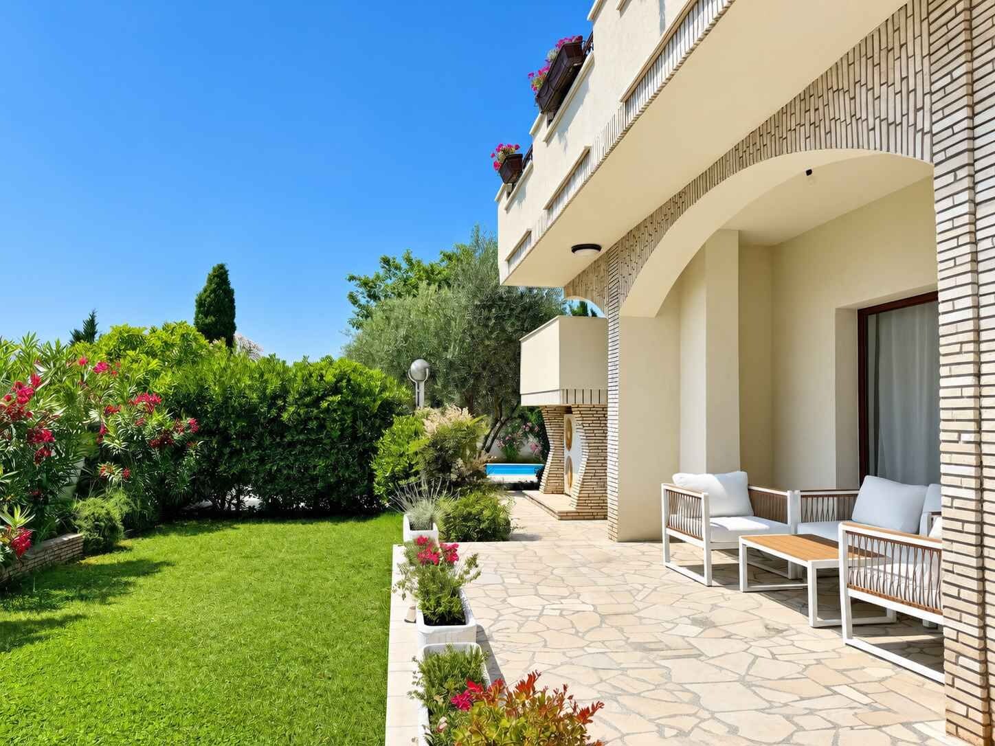 Un edificio residencial con patio, mobiliario exterior y piscina.
