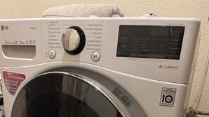 A white LG Direct Drive 22 kg washer with a digital display, a control panel, and a 10-year warranty sticker. - Chic 1-bedroom apartment with ocean views, sun bathing deck, pool in Ensenada. (Ensenada)