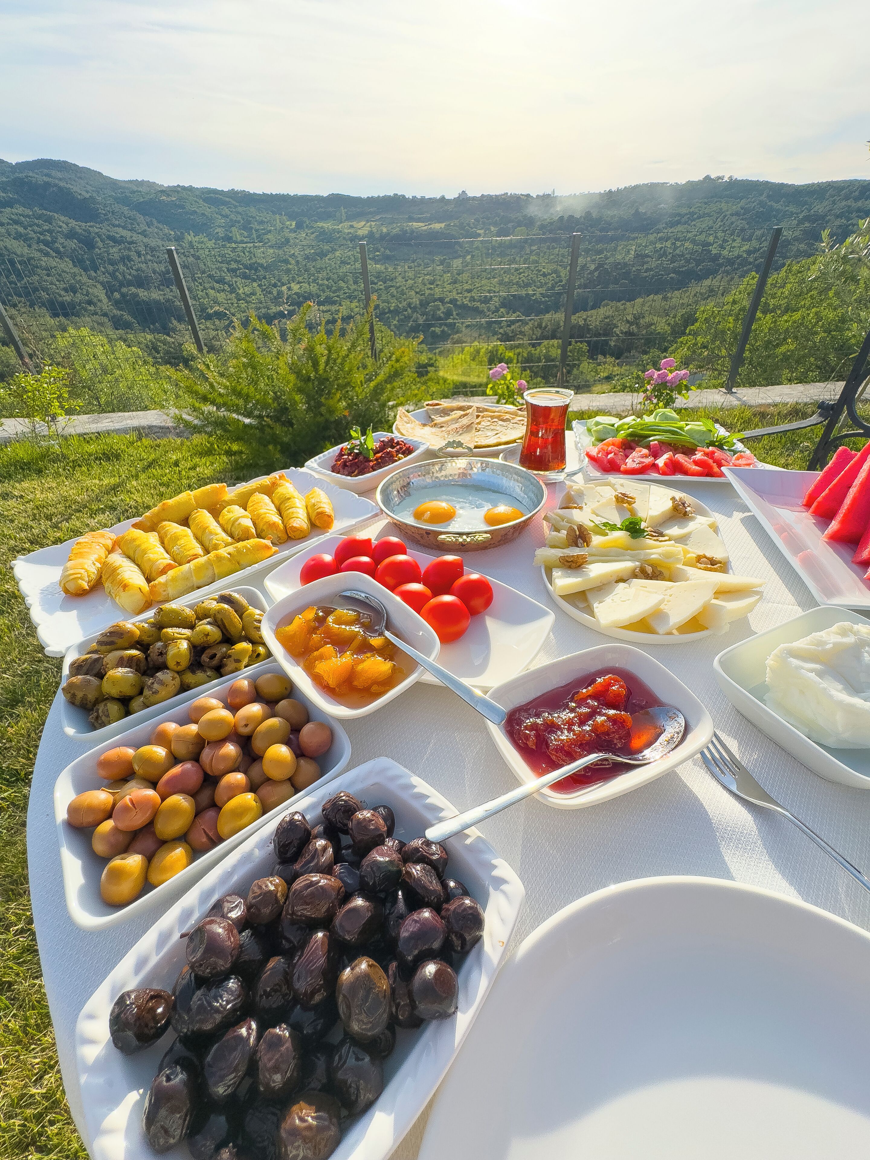 A table set with various food items and a scenic view in the background.
