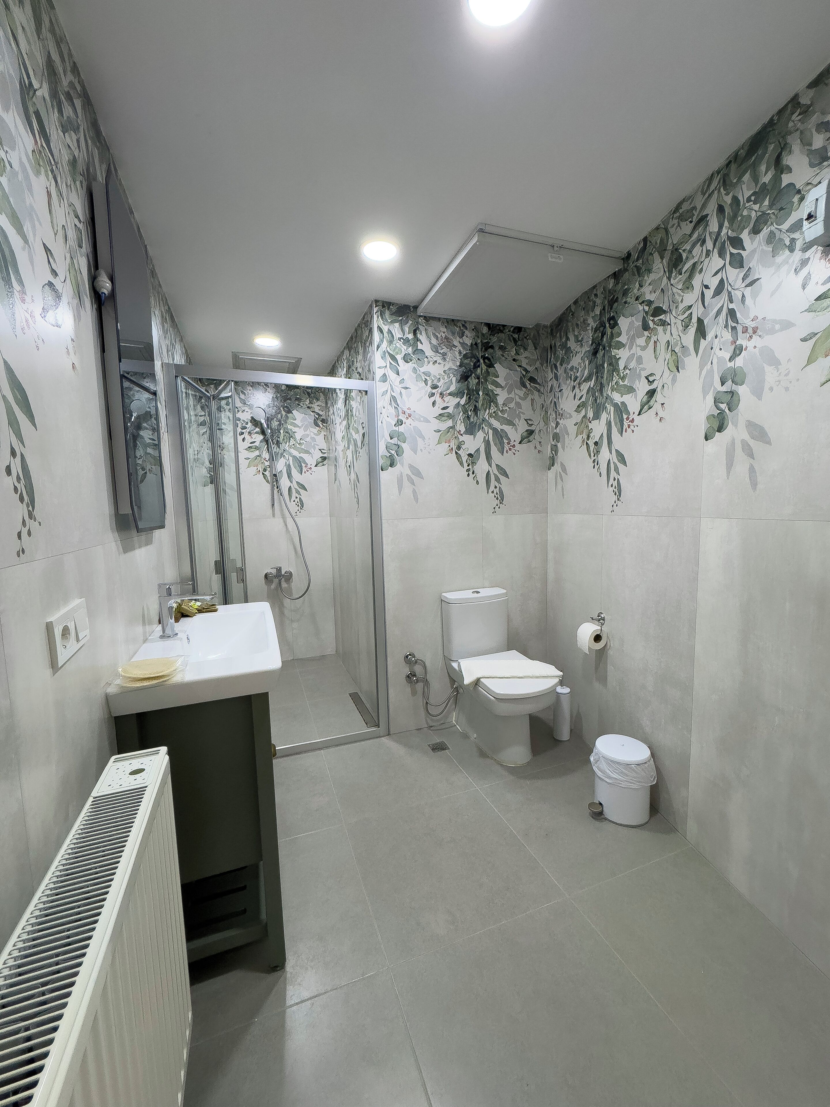 A bathroom with a shower, toilet, and sink.