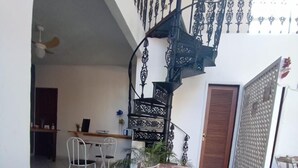 A dining table with breakfast items, a staircase, and a view of the interior. - POUSADA BELUGA (Buzios)