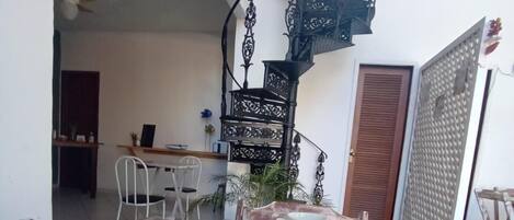 A dining table with breakfast items, a staircase, and a view of the interior.
