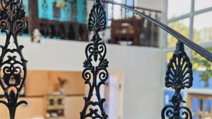 A staircase with ornate metal railings in a well-lit interior space. - POUSADA BELUGA (Buzios)