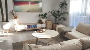 Una sala de estar con sofá, mesa de centro y estanterías.