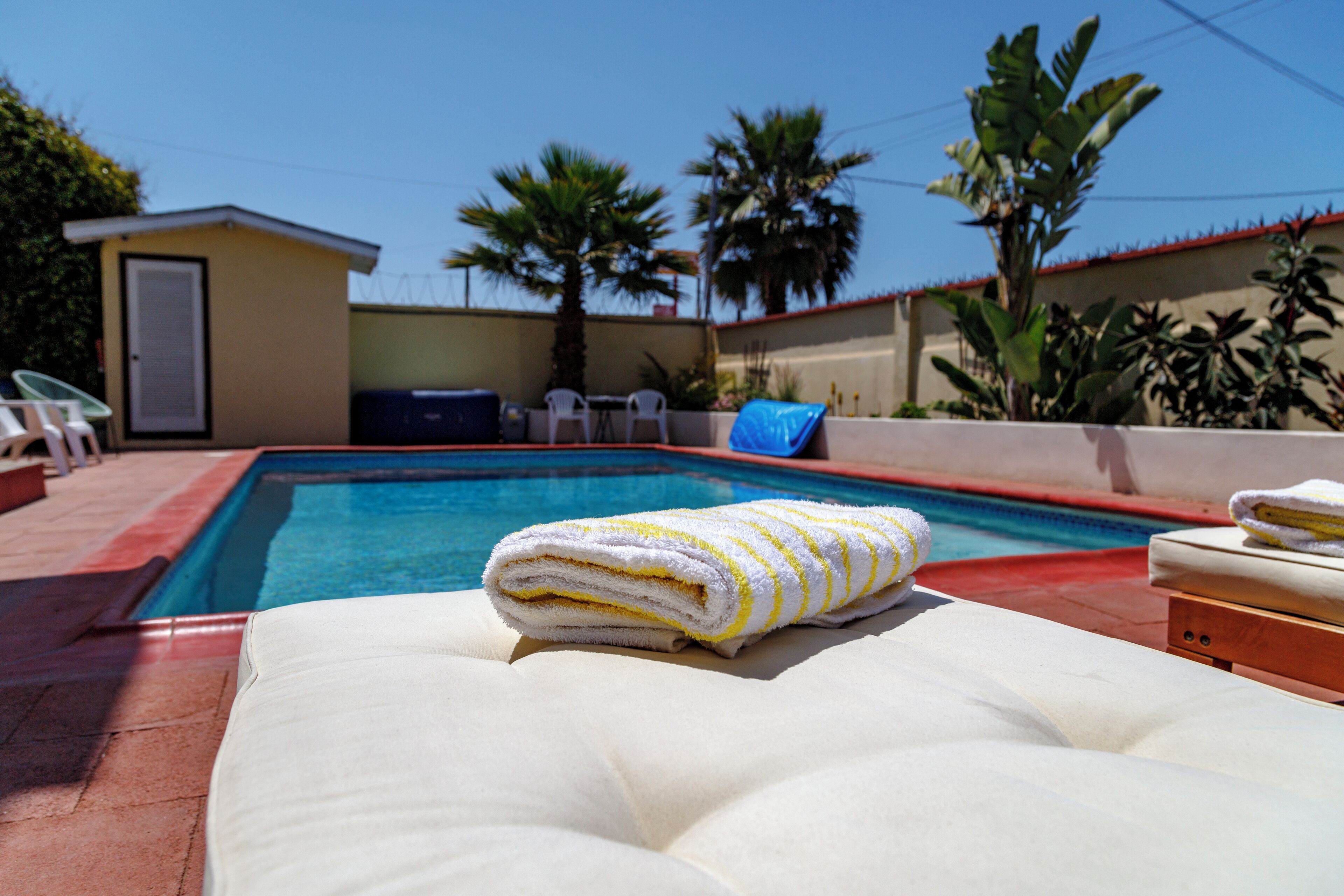 A poolside area with a lounge chair and a towel.