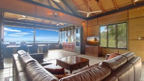 Relax in this spacious living area with a high ceiling and expansive ocean views from the balcony.
