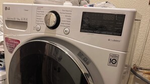 Een voorlader wasmachine van LG Direct Drive met een capaciteit van 22 kg en een garantie van 10 jaar, een bedieningspaneel en een transparante deur.