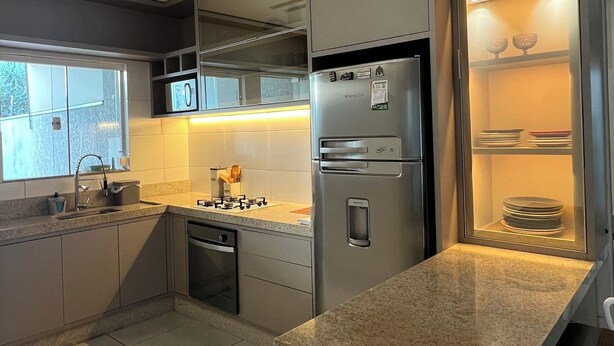 A modern kitchen with a granite countertop, stainless steel appliances, and a built-in oven.