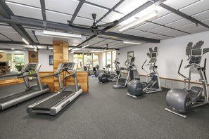 Un gimnasio con cintas de correr, elípticas y bicicletas estáticas.