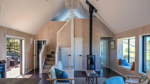 Een modern interieur met een trap, zithoek en een open haard.