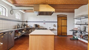 A kitchen with a central island, stainless steel appliances, a brick ceiling, and a tiled backsplash. - Margretehøj Manor in scenic surroundings (Grenaa)