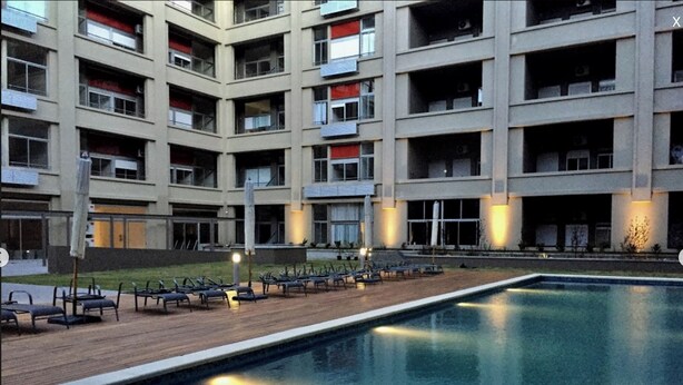 A modern building with multiple balconies and a swimming pool.