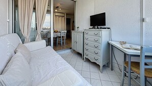 Ein Schlafzimmer mit einem Bett, einem Schreibtisch, einem Fernseher und einer Kommode.