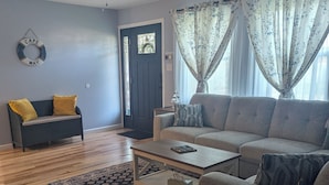 Un salon avec un canapé, une table basse et un ventilateur de plafond.