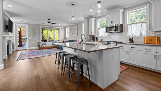 A spacious kitchen with a large island, white cabinetry, and modern appliances.