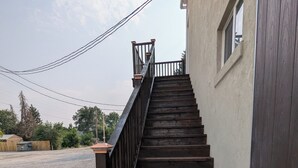 A wooden staircase with a metal railing leading up to a building. - New apartment on Main Street in Mackay (Mackay)