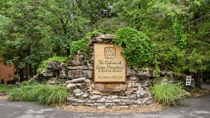 A wooden sign with a logo and text indicating 'The Cabins at Green Mountain A Festa Resort' and 'The Lodges at Maple Creek'. - Branson Cabin Near Attractions, Dining & Shows (Branson)