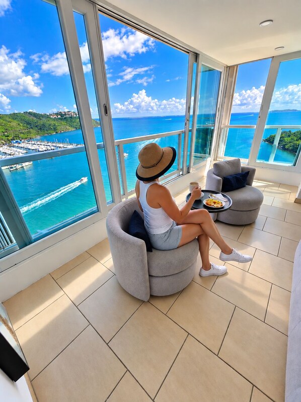 A spacious balcony with a clear view of the sea and a marina.