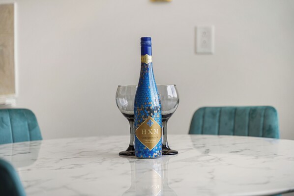 Une bouteille de champagne sur une table en marbre, avec deux verres.