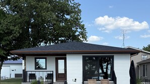 A single-story house with a front porch, a garage, and a large window.