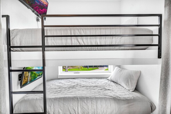A bunk bed with a window view, a shelf with a picture, and a bedside table. - Lake Travis Retreat w/ Pool, Views & Outdoor Kitchen. Perfect for groups (Lago Vista)