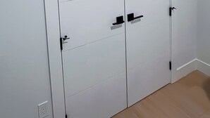 Un armario blanco con dos puertas, un tirador y un candado.