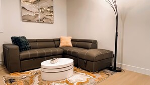 Una sala de estar moderna con un sofá modular, una mesa de centro redonda y una alfombra estampada.