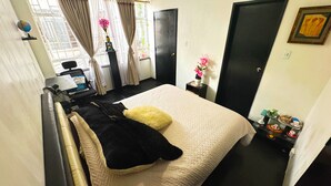 A bedroom with a bed, a desk, a chair, a globe, and a window with curtains. - Downtown private apartment (Bogotá)