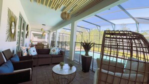 A sunlit patio with wicker furniture, a pool, and a view of the outdoors. - 10BR/5BA Retreat • Private Pool • Free Clubhouse Access-4573TB (Kissimmee)