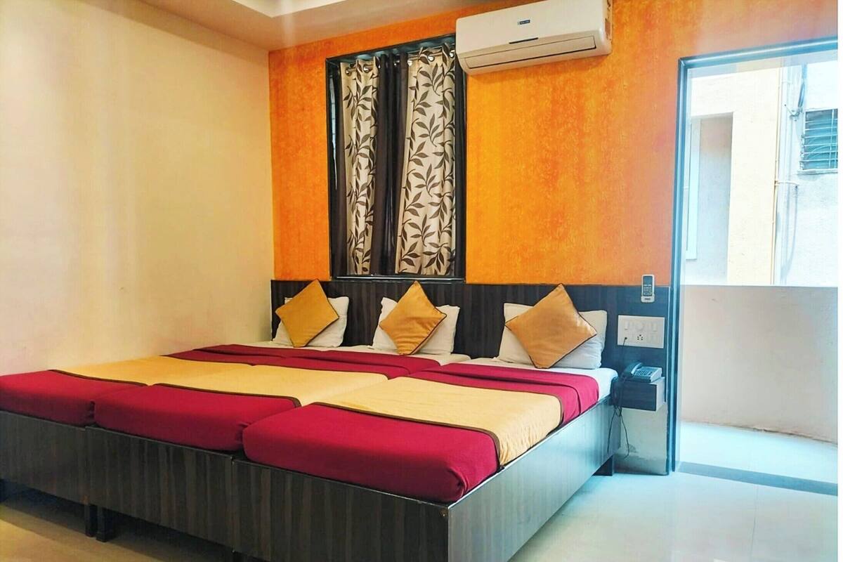 Une chambre d’hôtel avec un lit, une table de chevet, un appareil de climatisation et une vue sur l’extérieur.