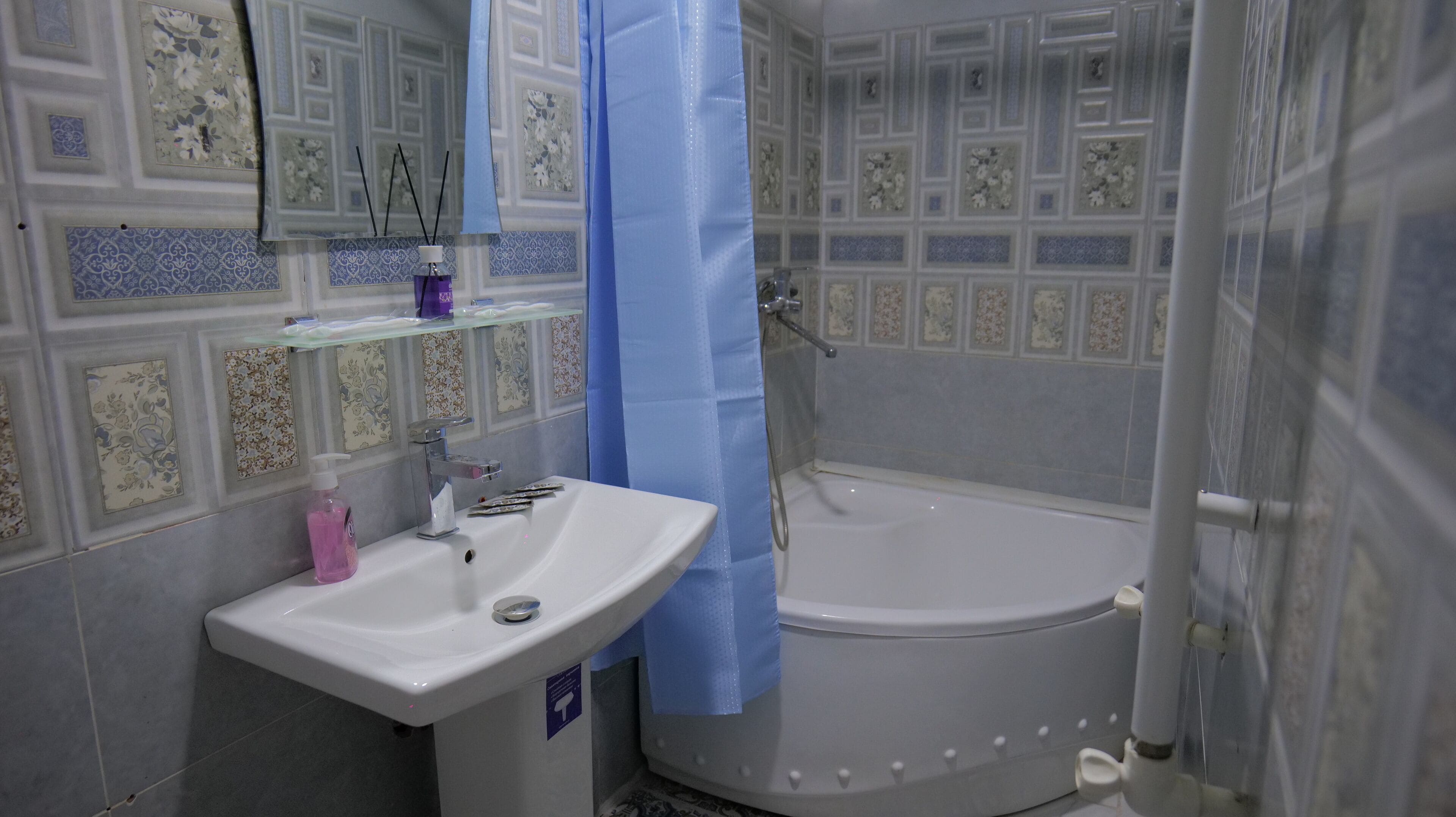 A bathroom with a white sink, a bathtub, and a shower curtain.