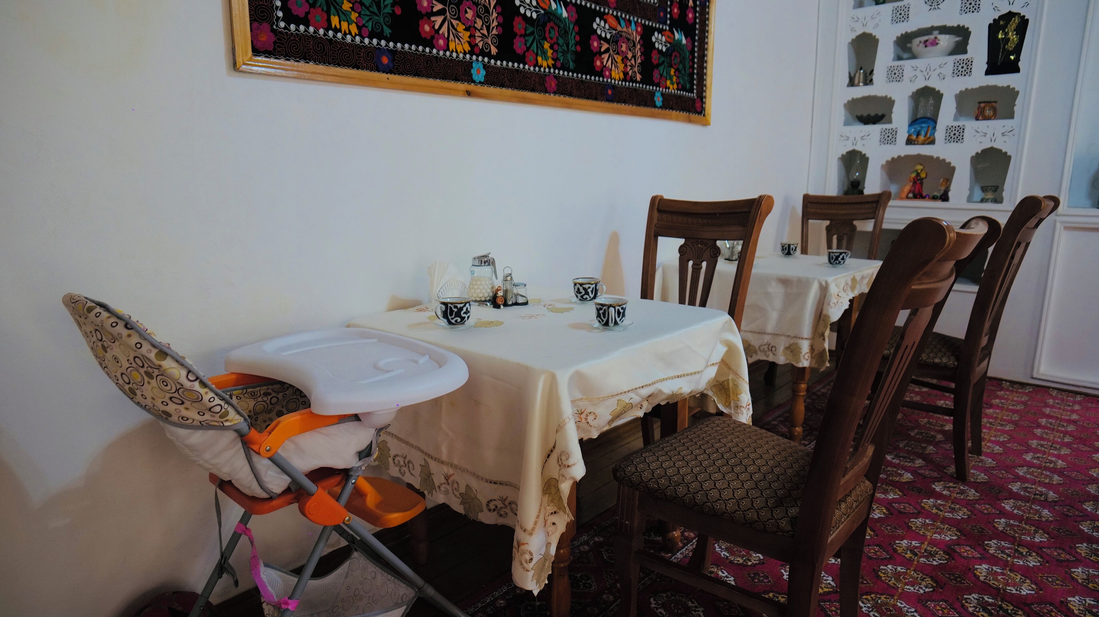 Comedor con una mesa alta, sillas y una trona para bebés.