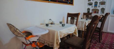 Comedor con una mesa alta, sillas y una trona para bebés.