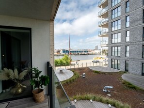 Enjoy a balcony view of the landscaped courtyard with a body of water and cityscape.