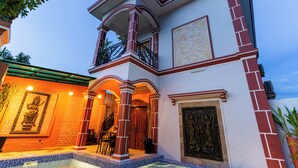A two-story building with a balcony, a staircase, and a large door with a decorative panel. - 855 Villa Siem Reap  (Siem Reap)