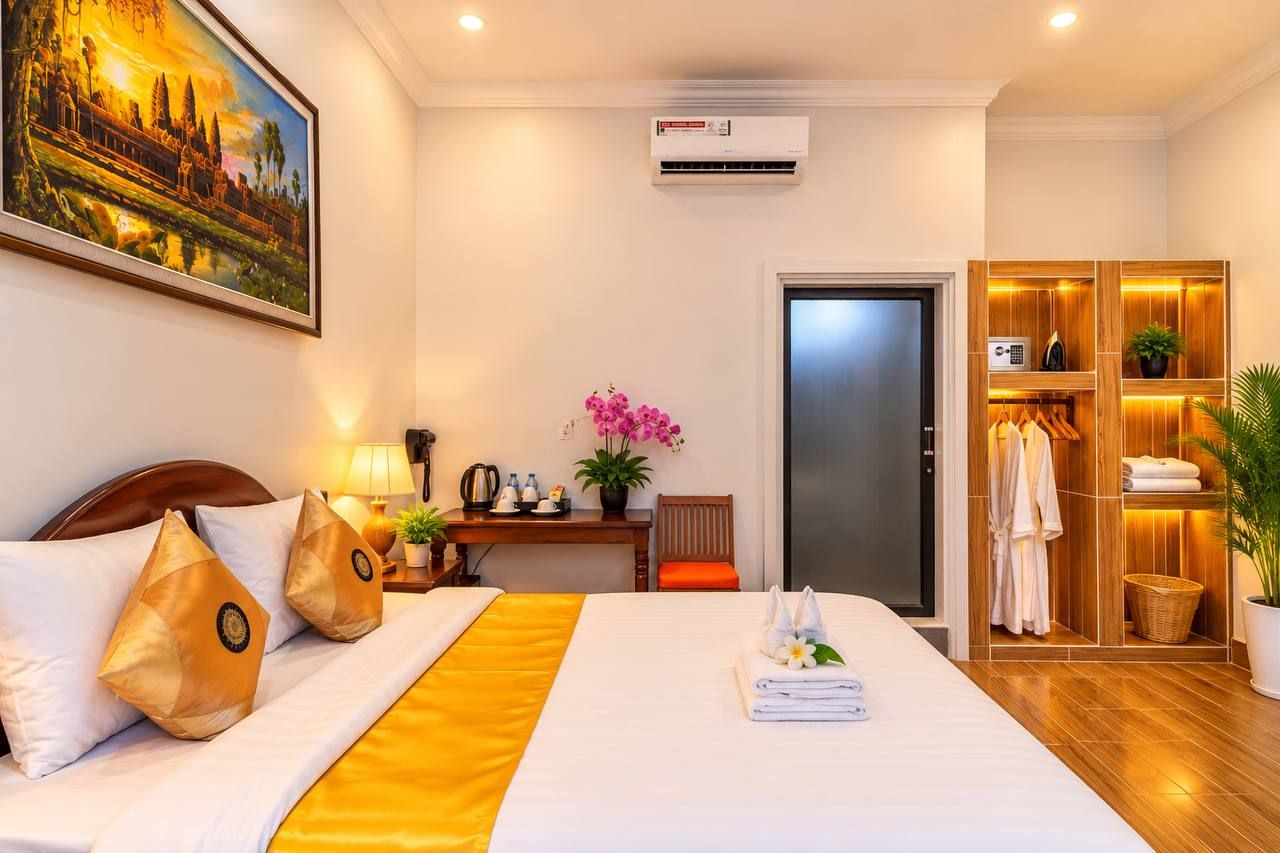 Habitación de hotel con cama, escritorio, armario y un cuadro en la pared.