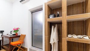 A bathroom with a wooden vanity, a shower area, and a seating area with a chair and table. - 855 Villa Siem Reap  (Siem Reap)