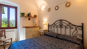 A bedroom with a bed, a chair, a desk, and a window. - Terrazza Bella Vista by Interhome (Lingueglietta)