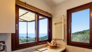 A kitchen with a view of the sea, a window with a wooden frame, a built-in oven, and a sink with a modern faucet. - Terrazza Bella Vista by Interhome (Lingueglietta)