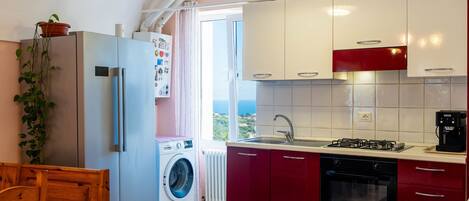 Réfrigérateur, un four, vaisselle et ustensiles