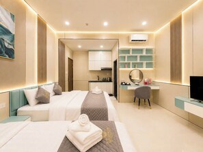 A hotel room with two beds, a desk, a chair, a TV, and a kitchenette. - Golden Sun Hotel Apartments 5 (Ho Chi Minh City)