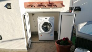 A laundry area with a washing machine, a drying machine, and a potted plant. - APARTMENT IN QUIET AREA, MINUTES FROM SPA PARKS AND BEACH, (FORIO)