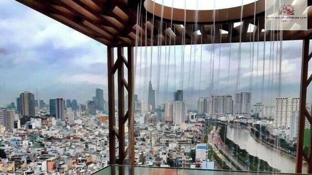 A person in a hot tub with a cityscape view. - ZENITY Skyline Residences Suite (Ho Chi Minh City)